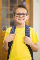 Smiling pupil with schoolbag in a classroom