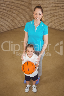 Student holding basketball with teacher