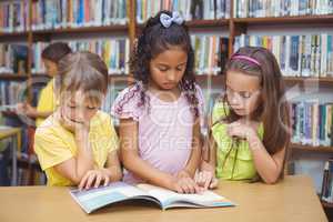 Pupils reading book together in library