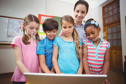 Teacher and pupils looking at laptop