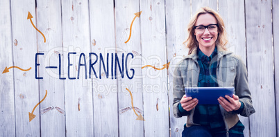 E-learning against smiling blonde in glasses using tablet pc