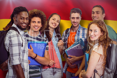 Composite image of smiling group of students holding folders