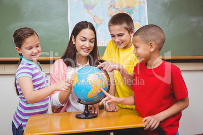 Students pointing to places on a globe