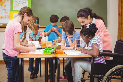 Pupils and teacher working at desk together