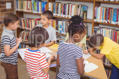 Pupils working together at desk in library