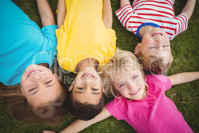 Smiling classmates lying in grass