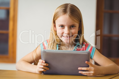 Cute pupil in class using tablet pc