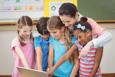 Teacher and pupils looking at laptop