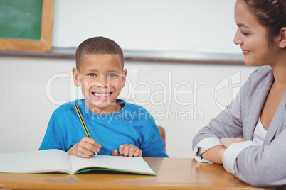 Smiling pupil being helped by teacher