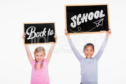 Composite image of elementary pupils holding jigsaw pieces