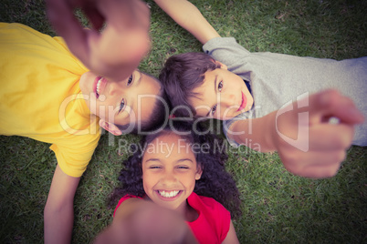 Cute pupils lying on grass smiling