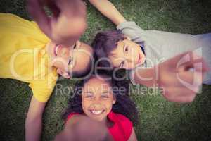 Cute pupils lying on grass smiling