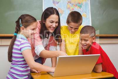 Students and teacher using a laptop