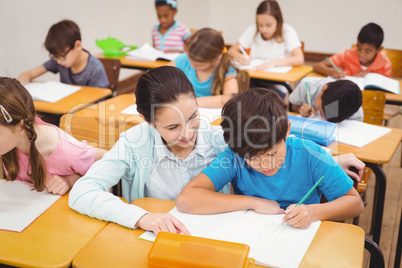 Teacher helping a little boy during class