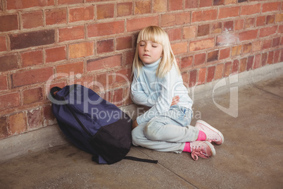 Sad pupil sitting alone on ground