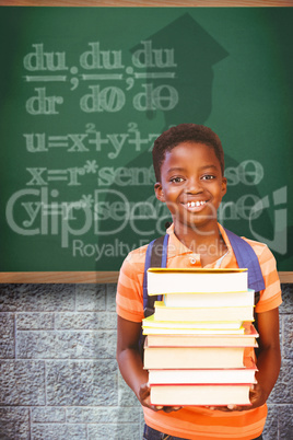 Composite image of cute little boy carrying books in library