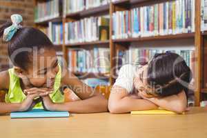 Smiling pupils leaning on books in the library