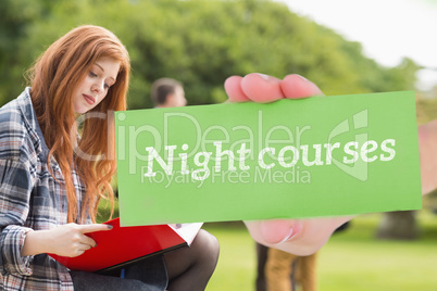 Night courses against pretty student studying outside on campus