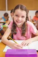 Little girl smiling at camera in class