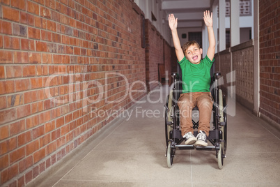 Smiling student in a wheelchair with arms raised