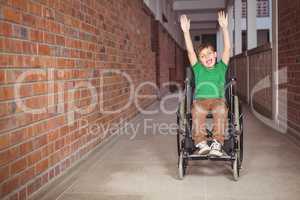 Smiling student in a wheelchair with arms raised