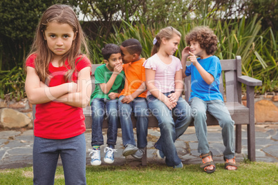 Upset child standing away from group