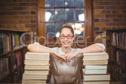 Blonde teacher standing between books in the library