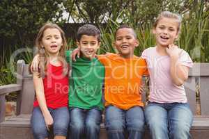 Happy children sitting together on a bench