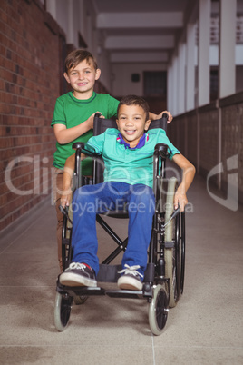 Smiling student in a wheelchair and friend beside him