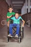 Smiling student in a wheelchair and friend beside him