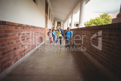 Happy pupils walking at corridor