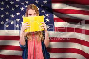 Composite image of student covering face with book in library