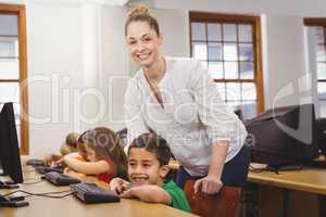 Teacher helping a student using a computer