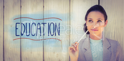 Education against stylish brunette thinking and smiling