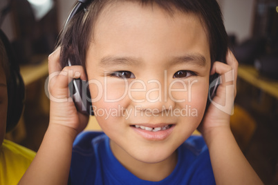 Cute pupil in computer class smiling at camera