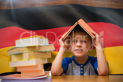 Composite image of cute boy with book on head