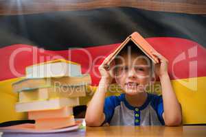 Composite image of cute boy with book on head