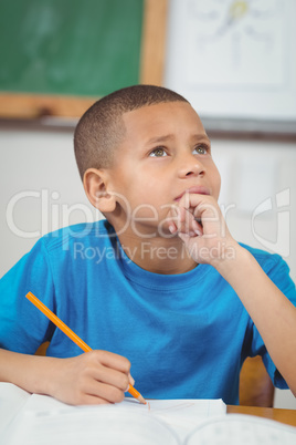 Concentrated pupil working at his desk in a classroom