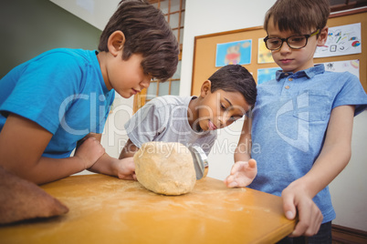 Pupils looking at rock with magnifying glass