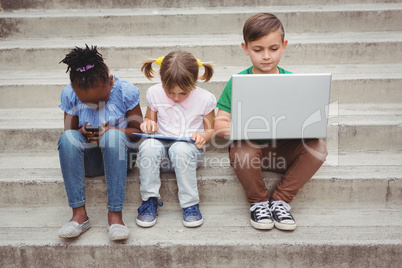 Students sitting on steps and using a tablet