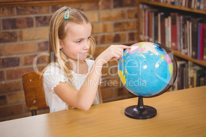 Students pointing to places on a globe