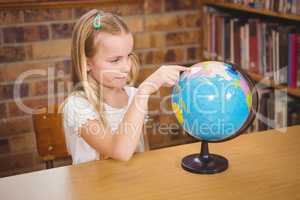 Students pointing to places on a globe