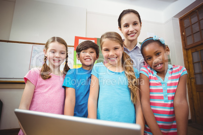 Teacher and pupils looking at laptop