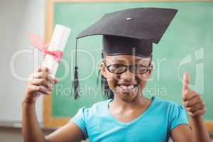 Smiling pupil with mortar board doing thumbs up