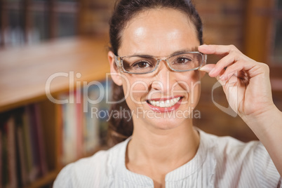 Smiling woman adjusting her glasses