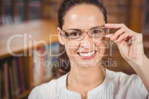 Smiling woman adjusting her glasses