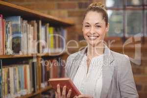 Blonde teacher holding book in the library