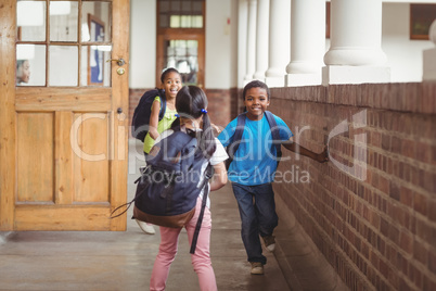 Happy pupils running around the corridor