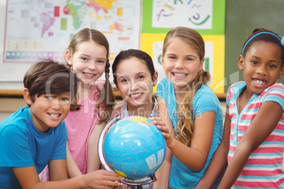 Teacher and pupils looking at globe