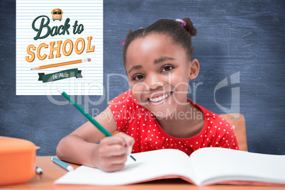 Composite image of cute pupils writing at desk in classroom